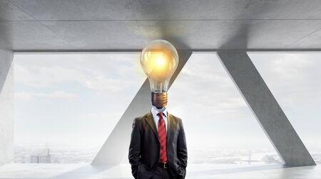 Businessman in modern interior with light bulb instead of headの写真素材