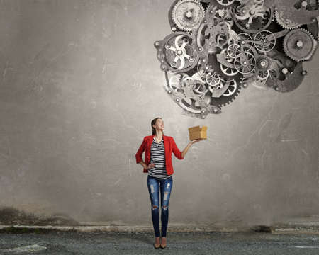 Young woman in red jacket holding carton box in handの写真素材