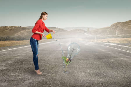 Young woman in red jacket holding yellow bucket in handsの写真素材