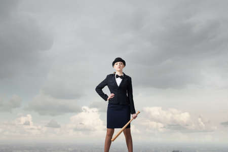 Young pretty woman in suit and hat with baseball bat