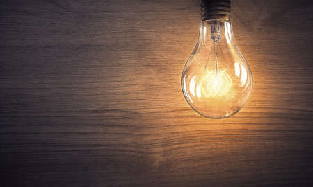 Power and energy concept with light bulb on wooden surfaceの写真素材