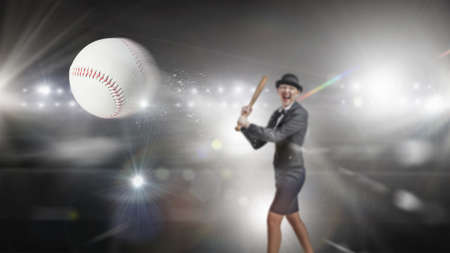 Young pretty woman in suit and hat with baseball batの写真素材