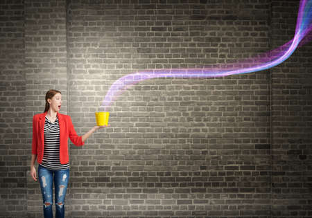 Young woman in red jacket holding yellow bucket in hands
