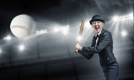 Young pretty woman in suit and hat with baseball bat