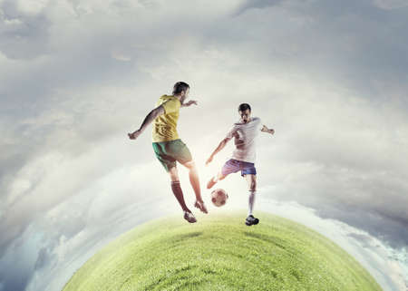 Football determined players outdoors fighting for ballの写真素材