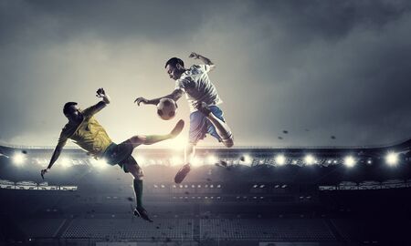 Football players at stadium field fighting for ballの写真素材