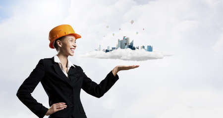 Woman engineer in hard hat showing construction projectの写真素材
