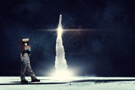 Cute kid girl with carton helmet on head dreaming to become astronaut