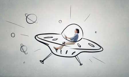 Funny image of woman flying in drawn spaceshipの写真素材