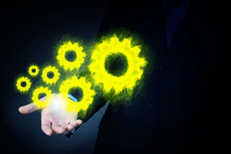 Hand of businessman and gear mechanism as teamwork conceptの写真素材