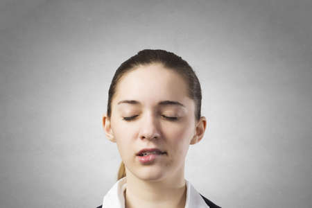Pretty young woman on concrete background thinking something overの写真素材