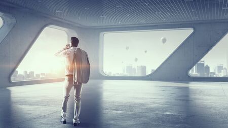 Man boss having mobile phone conversation while standing in modern officeの写真素材