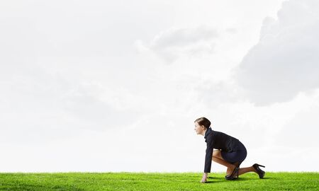 Young determined businesswoman standing in start position ready to competeの写真素材
