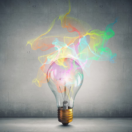 Glass glowing light bulb as idea sign on concrete backgroundの写真素材