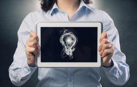 Confident young businesswoman working on digital tablet pc