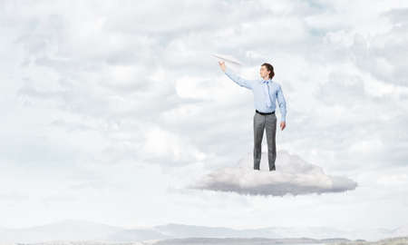 Young businessman with paper plane in handの写真素材