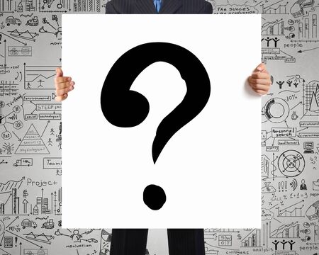 Young businessman showing banner with question markの写真素材