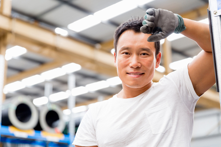 portrait of asian worker in production plant working on the factory floorの写真素材