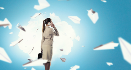 Successful businesswoman or entrepreneur talking on cellphone standing in modern officeの写真素材