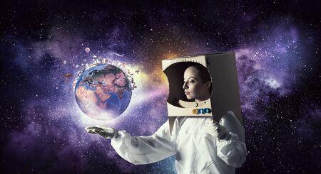 Young woman with carton box on head imagine she is astronaut. Elements of this image are furnished...
