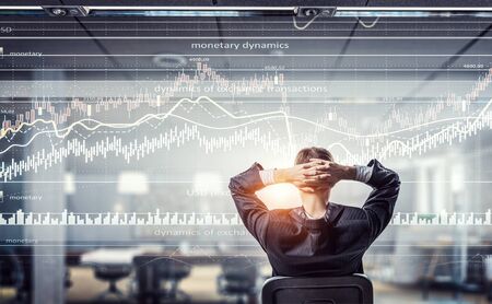 Relaxed businessman at the office sitting back with his hands behind his head