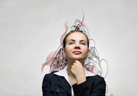 Pretty young woman with hand on chin thinking something overの写真素材