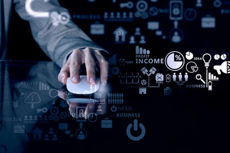 Hand of businesswoman on dark background using wireless computer mouseの写真素材