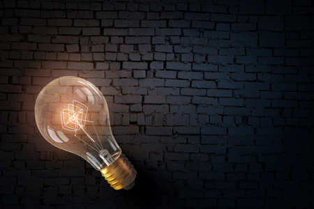 One turned on light bulb on brick wall backgroundの写真素材