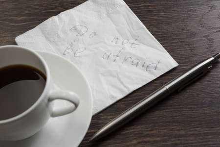 Message written on napkin and coffee cup on wooden napkin