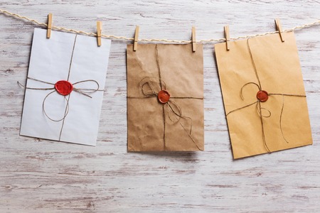 Old envelopes hanging on rope fixed with clothes pegの写真素材