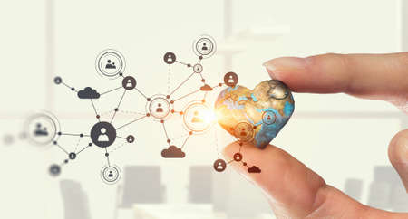 Female hand holding Earth planet between fingers. Elements of this image are furnished by NASAの写真素材