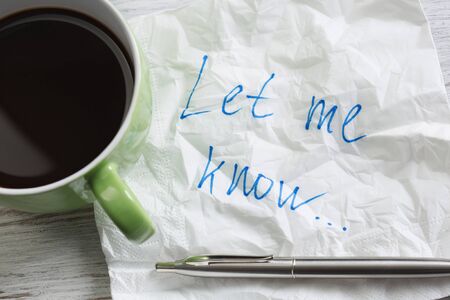 Romantic message written on napkin and cup of coffee on wooden tableの写真素材