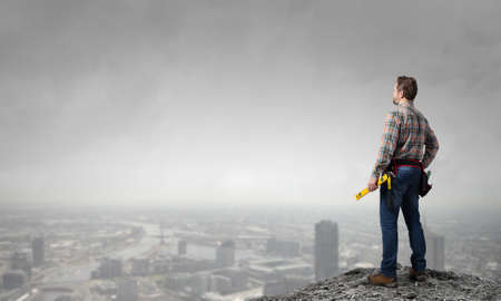 Builder man in checked shirt with tool belt on waistの写真素材