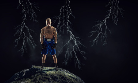 Strong boxer on dark background demonstrating power and enduranceの写真素材