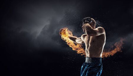 Strong boxer on dark background demonstrating power and enduranceの写真素材