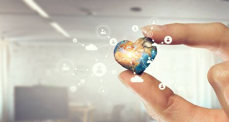 Female hand holding Earth planet between fingers. Elements of this image are furnished by NASAの写真素材