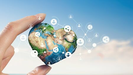 Female hand holding Earth planet between fingers. Elements of this image are furnished by NASAの写真素材