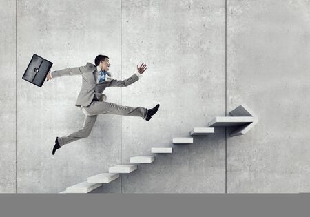 Happy businessman perform success dancing on arrow graphの写真素材