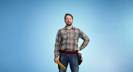 Builder man in checked shirt with tool belt on waist