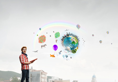 Hipster guy with book in hands outdoors. Elements of this image are furnished by NASAの写真素材