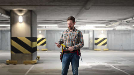 Builder man in checked shirt with tool belt on waist. Mixed mediaの写真素材