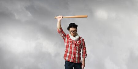 Hipster guy in checked shirt and hat with baseball bat