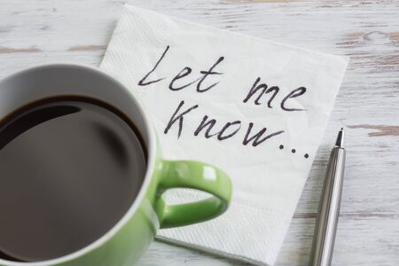 Romantic message written on napkin and cup of coffee on wooden tableの写真素材