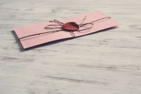 Old post concept with envelope with wax seal on wooden surface