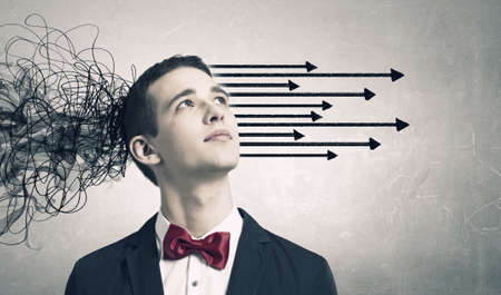 Thoughtful businessman with arrows and thoughts coming out of his headの写真素材