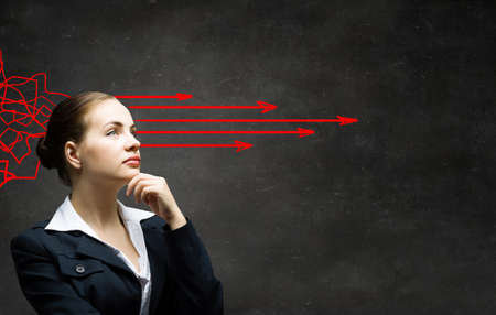 Pretty young woman making decision with arrows coming out of her headの写真素材