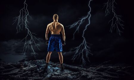 Strong boxer on dark background demonstrating power and enduranceの写真素材