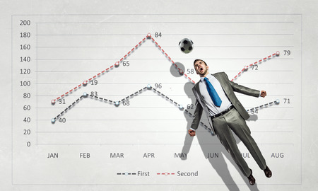 Football player hitting ball and progress infographs at backgroundの写真素材