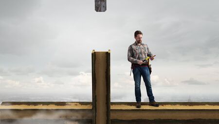 Builder man in checked shirt with tool belt on waist
