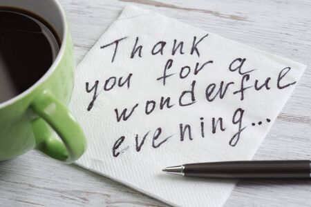 Romantic message written on napkin and cup of coffee on wooden tableの写真素材
